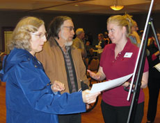 citizens ask questions about a display board at an open house in Lee's Summit